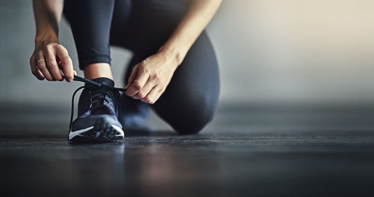 Woman lacing up running shoes